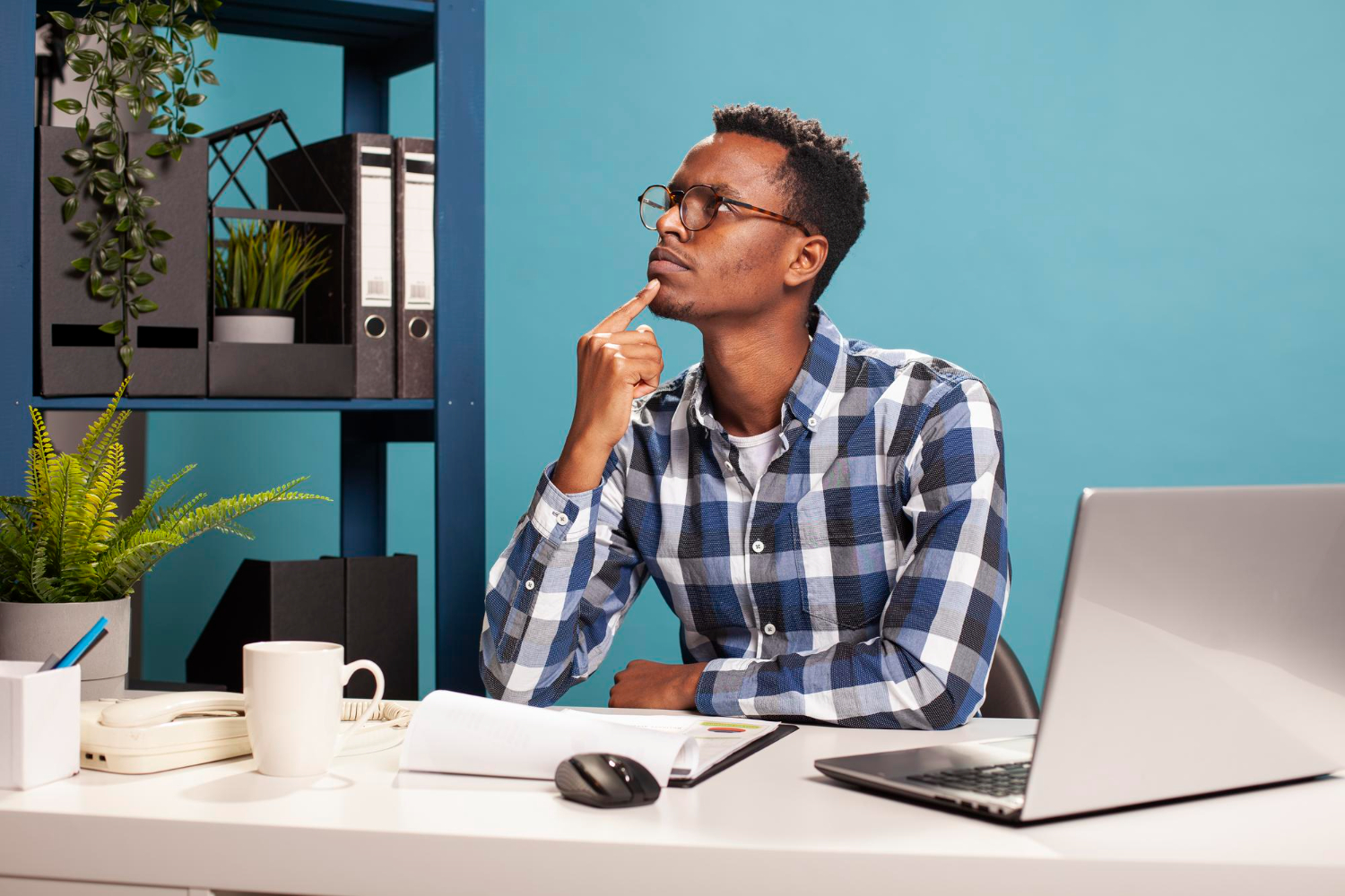 A professional working thoughtfully at a laptop, reflecting on how digital systems shape modern writing and communication.