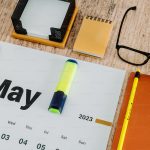 Desk calendar and notebook representing planning and effective time management.