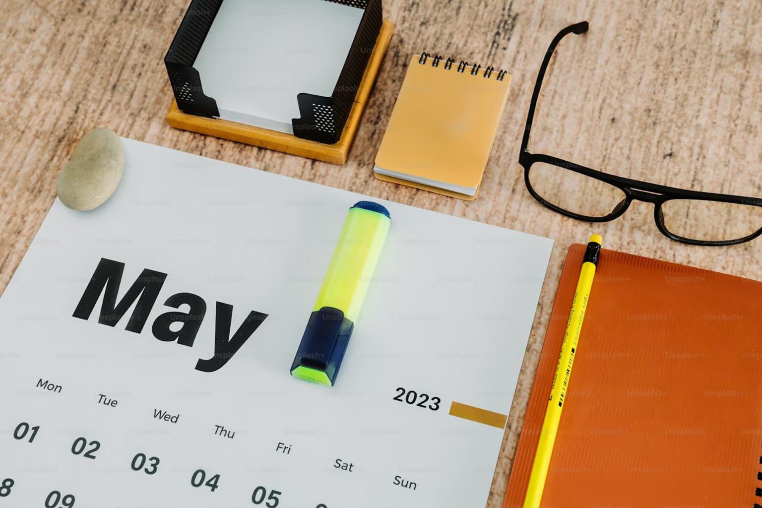 Desk calendar and notebook representing planning and effective time management.