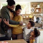 Multi-generational African family talking together in a kitchen, reflecting evolving family structures and shared responsibility.