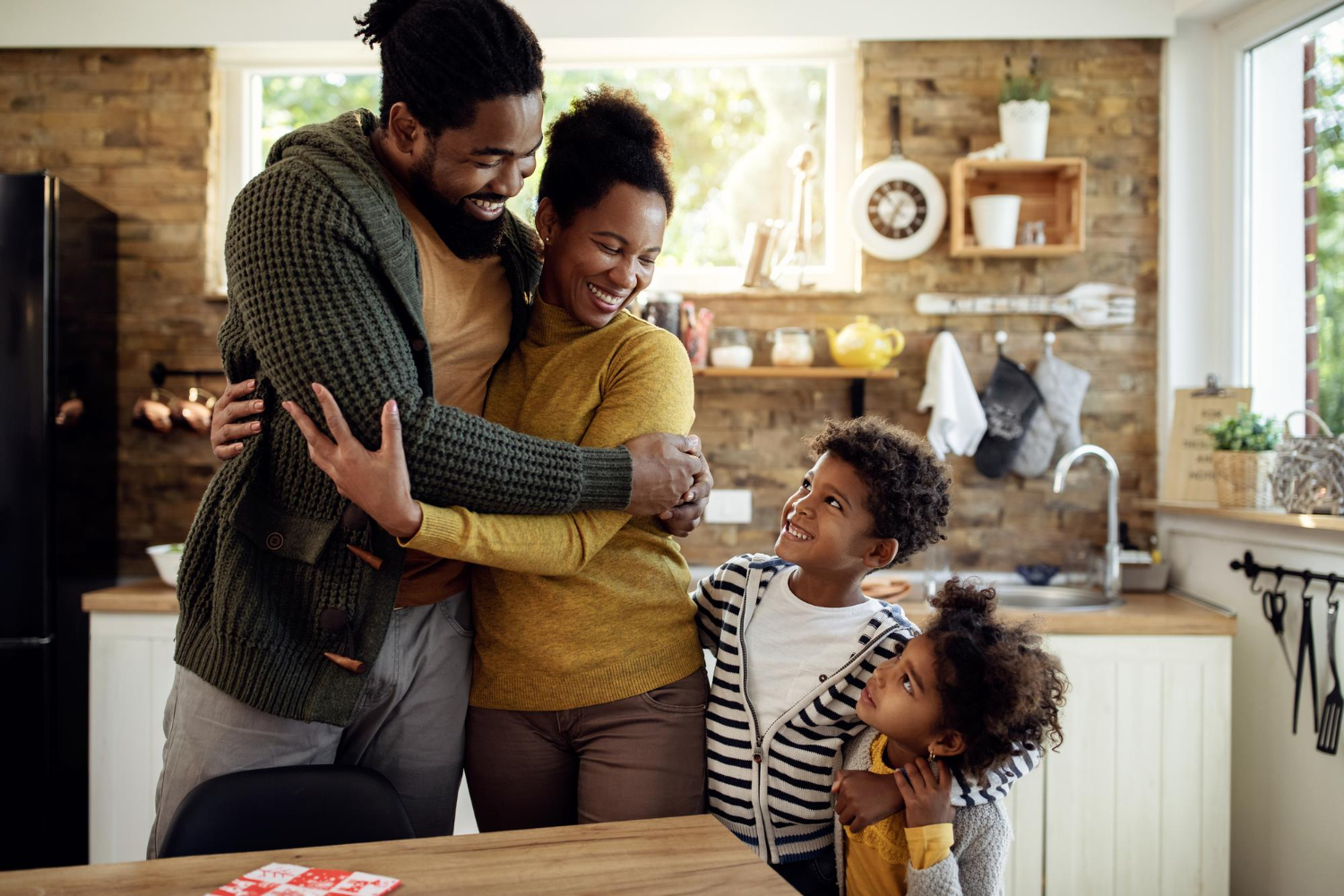 Multi-generational African family talking together in a kitchen, reflecting evolving family structures and shared responsibility.