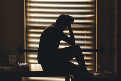 A silhouetted person alone and worried, reflecting the psychological isolation and vulnerability conditions behind drug addiction