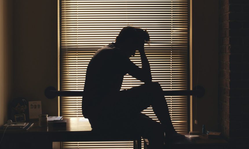 A silhouetted person alone and worried, reflecting the psychological isolation and vulnerability conditions behind drug addiction