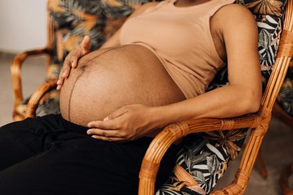 Pregnant woman sitting calmly with hands on her belly, reflecting on emotional wellbeing during pregnancy