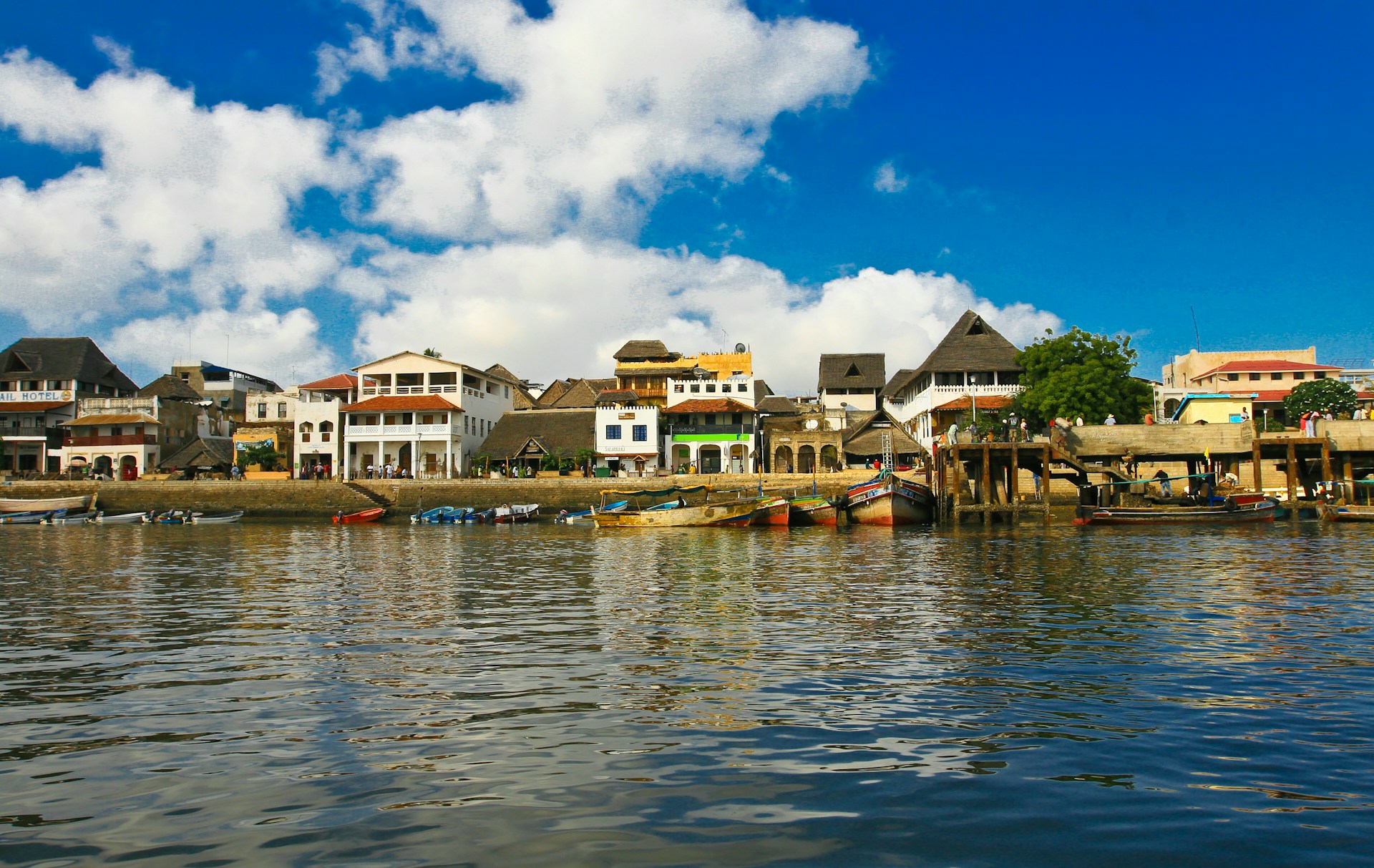 Waterfront view of Lamu Old Town with Swahili buildings and boats along the coastline in Kenya